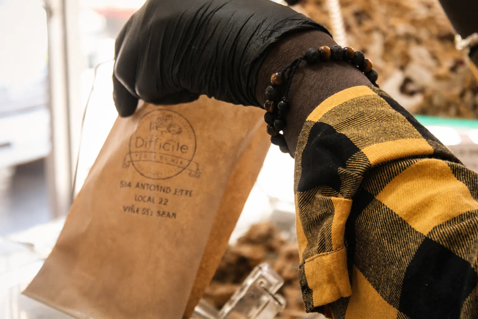 Bolsa artesanal de papel kraft con la marca Difficile sobre los dispensadores a granel